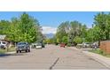 A quiet tree-lined street showcases the neighborhood with mountain views in the distance at 717 E 4Th Ave, Longmont, CO 80504