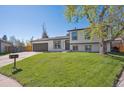 Charming two-story home boasts fresh landscaping and a large, well-maintained front lawn at 8004 S Field St, Littleton, CO 80128