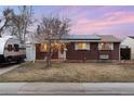 Charming single-story brick home featuring solar panels and a quaint front yard with swing at 6903 W 52Nd Pl, Arvada, CO 80002