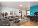 Staged living room with hardwood floors and an open floor plan to the dining area, perfect for entertaining at 6903 W 52Nd Pl, Arvada, CO 80002
