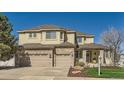 Inviting home featuring a stone-accented facade, a three-car garage, and a landscaped front yard at 10337 Carriage Club Dr, Lone Tree, CO 80124