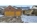 Charming two-story brick and siding home with a two-car garage, solar panels, and a snow-covered front yard at 6596 Silverleaf Ave, Firestone, CO 80504