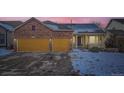 Inviting home featuring a brick facade, solar panels, two-car garage, and charming front porch at 6596 Silverleaf Ave, Firestone, CO 80504