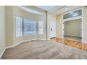 Cozy living room features neutral carpet, hardwood floors, and bright natural light at 6596 Silverleaf Ave, Firestone, CO 80504
