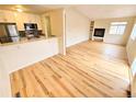 Open-concept living area featuring a modern fireplace and light wood floors at 1125 S Oneida St # F, Denver, CO 80224