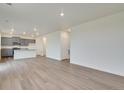 Open-concept living space with modern gray cabinets and plank flooring throughout the home at 1639 Pinnacle Ave, Lochbuie, CO 80603