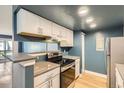 Well-lit kitchen featuring stainless steel appliances and white cabinets with ample counter space at 14453 E Jewell Ave # 104, Aurora, CO 80012