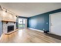 Bright living room featuring a stone fireplace and sliding doors to the balcony at 14453 E Jewell Ave # 104, Aurora, CO 80012