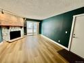 Living room with fireplace, wood-look floors, and teal walls at 14453 E Jewell Ave # 104, Aurora, CO 80012