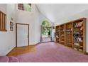 Bright foyer with a soaring ceiling, arched window, and beautiful custom wooden bookcase at 11366 Haswell Dr, Parker, CO 80134
