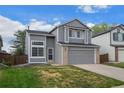 Charming gray two-story home with a well-maintained lawn and attached two-car garage at 9522 Castle Ridge Cir, Highlands Ranch, CO 80129