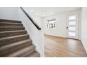 Welcoming entryway showcasing stairs with dark trim and wood-look flooring, providing a modern and inviting space at 24737 E 40Th Ave, Aurora, CO 80019