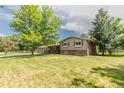 Sprawling home on a lush green lot with mature trees, brick exterior and large lawn at 13990 Berry Rd, Golden, CO 80401