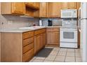Well-lit kitchen with practical layout, wood cabinets, and tile flooring at 710 S Clinton St # 1A, Denver, CO 80247