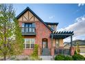 Charming two-story brick home featuring a cozy front porch, a balcony, and a well-manicured yard at 237 Dayton St, Denver, CO 80230