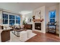 Bright living room with a fireplace, hardwood floors, and large windows at 237 Dayton St, Denver, CO 80230