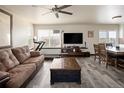 Bright living area with comfortable seating, a ceiling fan, and a modern entertainment center at 21742 E Lehigh Pl, Aurora, CO 80018