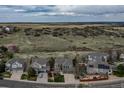 Aerial view showcases a residential neighborhood surrounded by natural open spaces and green hills at 1563 Baguette Dr, Castle Rock, CO 80108