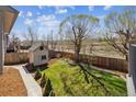 Serene backyard showcases a lush lawn, mature trees, and a charming shed at 1479 S Jasper St, Aurora, CO 80017