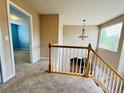 Well-lit upstairs hallway with plush carpeting, providing access to the bedrooms at 6188 Viewpoint Ave, Firestone, CO 80504