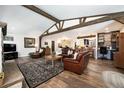 Open-concept living room featuring exposed beams and wood floors at 10601 W 78Th Ave, Arvada, CO 80005
