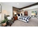 Comfortable bedroom with wood accent wall and patio access at 10601 W 78Th Ave, Arvada, CO 80005