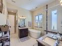 Bright bathroom with a modern soaking tub, glass-enclosed shower, and dual vanity sinks at 28665 Tepees Way, Evergreen, CO 80439
