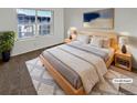 Bright bedroom with a wooden bed frame, white linens, bedside tables, and a large window offering natural light at 1256 S Zeno Cir # E, Aurora, CO 80017