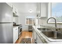 Well-lit kitchen with stainless steel appliances, granite countertops, and white cabinets, offering a modern cooking space at 1924 Yosemite St, Denver, CO 80220