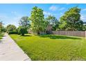 Expansive lawn surrounds this inviting home, complemented by mature trees and a privacy fence at 3039 W 22Nd Ave, Denver, CO 80211