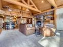 Inviting living room with a stone fireplace, wood beams, and an open layout to kitchen and dining at 7076 Boreas Rd, Larkspur, CO 80118