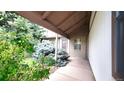 Inviting covered front porch with brick accents and lush greenery leading to the entrance at 6463 Brentwood St, Arvada, CO 80004