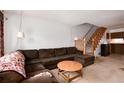Cozy living room with a comfortable brown sectional sofa and staircase at 14272 E Hawaii Cir # B, Aurora, CO 80012
