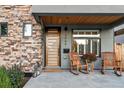 Inviting home entrance with a modern front door, stone accents, and a cozy porch seating area at 4566 Xavier St, Denver, CO 80212