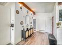Inviting foyer with wood floors, decorative wall art, console table, and a view into the living area at 450 Yukon St, Lakewood, CO 80226