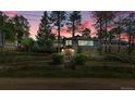 Charming gray home with stone accents and mature trees at dusk in a picturesque setting at 350 Tower Hill Cir, Golden, CO 80401