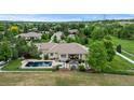 Aerial view of the backyard showcases a pool, hot tub, patio, gazebo, and lush green grass at 5653 Yank St, Arvada, CO 80002