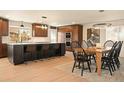 Open concept kitchen with island seating, pendant lighting, and seamless dining area at 6844 W 69Th Pl, Arvada, CO 80003