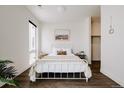 Serene bedroom with a white metal bed, minimalist decor, and ample natural light, creating a peaceful retreat at 1898 S Bannock St # 510, Denver, CO 80223
