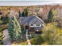 Stunning aerial view of a brick home nestled among mature trees with a lush, landscaped yard at 2464 Ginny Way, Lafayette, CO 80026