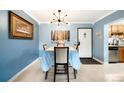 Bright dining room with table and seating, stylish light fixture, and tiled floor at 7780 W 38Th Ave # 203, Wheat Ridge, CO 80033