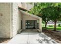 Building entrance featuring glass doors, stone facade, benches, and landscaping at 7780 W 38Th Ave # 203, Wheat Ridge, CO 80033