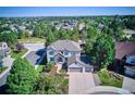 An aerial view of a beautiful home nestled in a lush, green neighborhood at 327 Ingleton Ct, Castle Pines, CO 80108