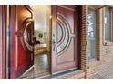 Elegant entryway features a unique front door and brick flooring at 7845 Armadillo Trl, Evergreen, CO 80439