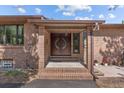 Covered front entrance with brick pillars and a decorative double door with a decorative, circular glass panel at 7845 Armadillo Trl, Evergreen, CO 80439