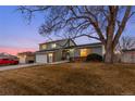 Charming two-story home with an attached garage and a large tree in the front yard at 4350 E 112Th Pl, Thornton, CO 80233