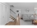 Bright living room features hardwood floors, a gray sofa, and access to the staircase at 4350 E 112Th Pl, Thornton, CO 80233