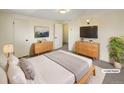 A staged bedroom features two dressers, a cozy bed, and a decorative plant at 1391 Vance St, Lakewood, CO 80214