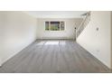 An empty living room with neutral carpet, white walls, and a large window for great natural light at 1391 Vance St, Lakewood, CO 80214