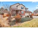 Two-story home with landscaping, a front porch, and a two-car garage at 6100 E 133Rd Ave, Thornton, CO 80602